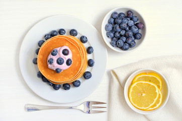 Pancakes with blueberry on white plate, fresh blueberry in bowl