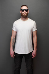 Hipster handsome male model with beard wearing white blank t-shirt with space for your logo or
