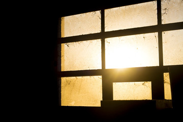 Sunset light through dirty stable window