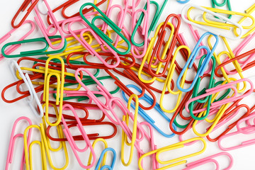 A lot of colorful paper clips on white background.