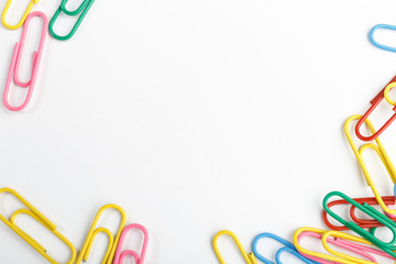 A lot of colorful paper clips on white background.