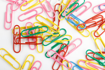 A lot of colorful paper clips on white background.