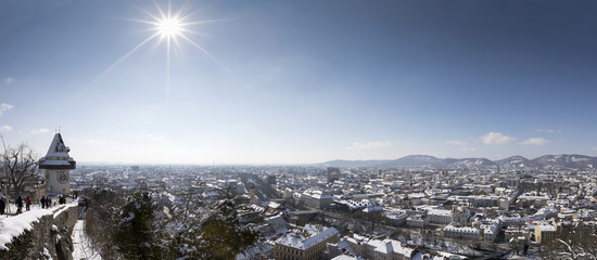 panoramic view of clocktower uhrturm on schlossberg hill in winter, graz, austria