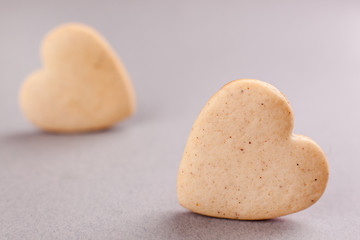 cookies in the shape of heart on a gray background, minimalism, concept of cooking, baking, symbol of love