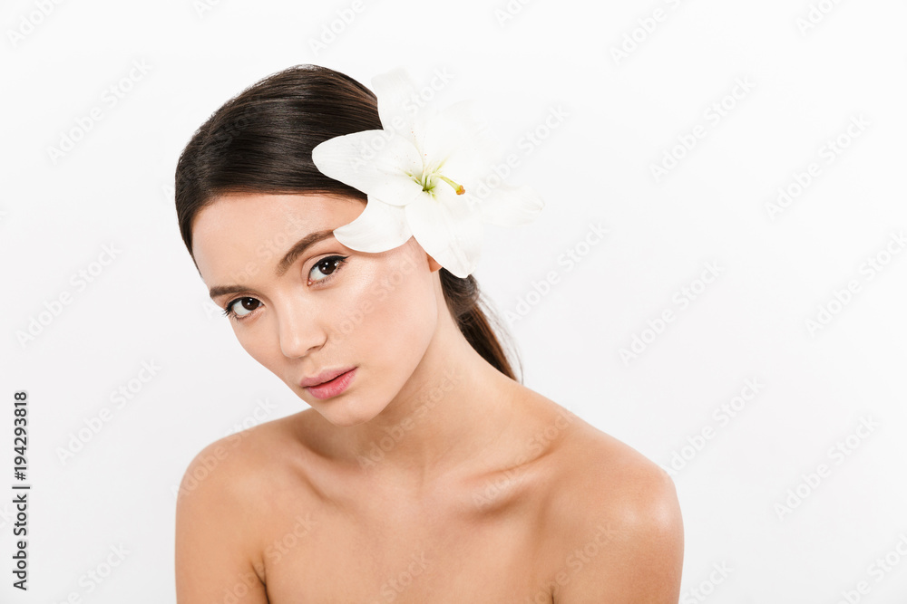 Canvas Prints confident beautiful half-naked woman with lily flower in hair looking camera