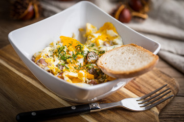 Scrambled eggs with sausage and bread.