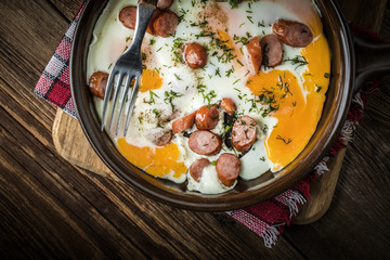 Tasty cooked egg with chopped sausages.