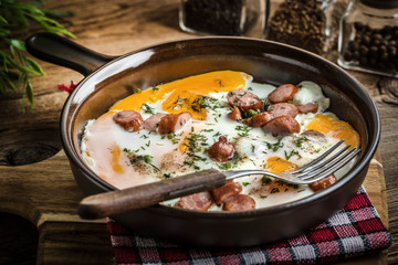 Tasty cooked egg with chopped sausages.