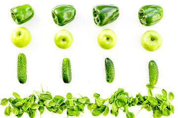 Green vegetables pattern. Shiny bell pepper, cucumber, arugula salad and fresh apple on white background top view copy space