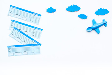 Family trip concept. Airplan toy, clouds, airplan tickets on white background top view copy space