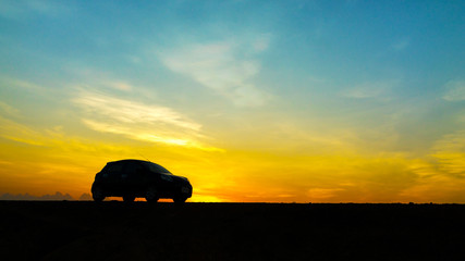Cars parked on rural road in the morning have sunrise background