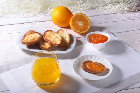 healthy Morning Breakfast set with orange jam on bread toast and juice in glass.