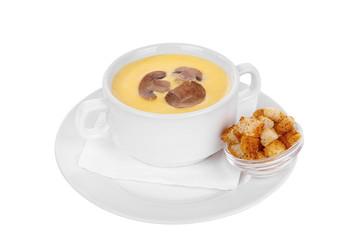 Soup puree, cream soup yellow with mushrooms, championons and crackers, dry bread. On a napkin in a white plate isolated white. Serving dishes in a cafe, restaurant, for a menu. Side view