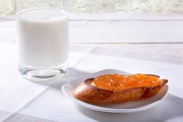 Morning Breakfast set with orange jam on bread toast and milk in glass.