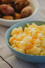 Bowls with chopped fresh and raw vegetables in small pieces prepared for veggie soup cooking