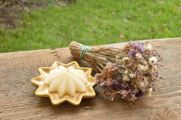 star candle and dry flower on wooden background.