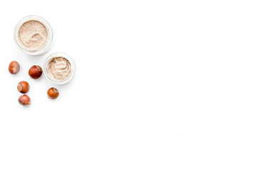 Natural cosmetics for skin care. Body scrub with hazelnut. White background top view copy space