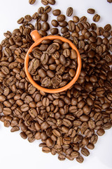 Coffee bean in small mug on white background. Fried coffee beans in a cup, can be used as a background