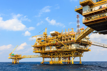 Offshore oil and Gas central processing platform and remote platform produced oil, natural gas and liquid condensate for set to onshore refinery from offshore in ocean sea background.
