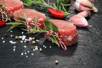 Raw beef fillet steaks mignon on dark background