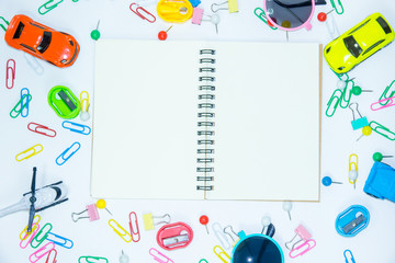 Blank notebook with paper clips with toys on white background. Education concept.