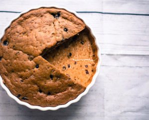 Pie with blueberries in ceramic bowl with ribbon on wooden table