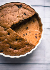 Pie with blueberries in ceramic bowl with ribbon on wooden table