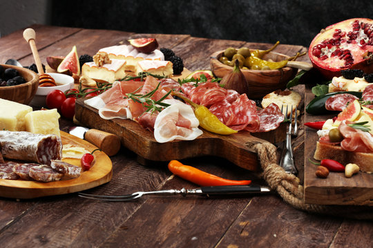 Italian antipasti wine snacks set. Cheese variety, Mediterranean olives, pickles, Prosciutto di Parma and salami