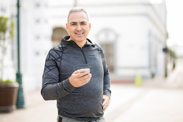 Handsome middle-aged man taking break from workout