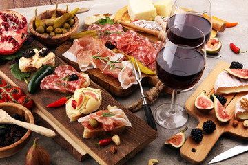 Italian antipasti wine snacks set. Cheese variety, Mediterranean olives, pickles, Prosciutto di Parma and salami