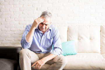 Mature man having severe headache at home