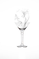 Martini glass with artificial smoke in it isolated on white background
