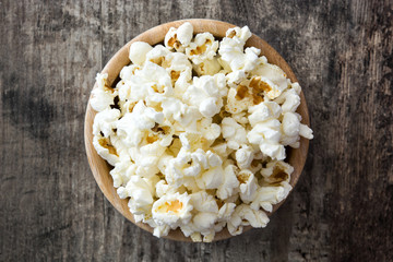 Popcorn in bowl on wooden table. Top view

