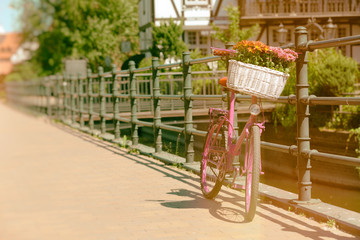 pink bike standing by metal barrier