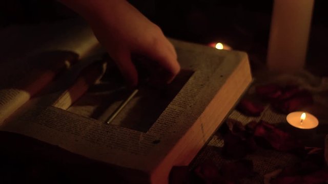 A woman's hand takes out a key from an old cache book