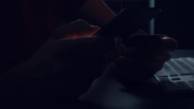 Mobile banking conceptual low key footage with male hand using smart phone app and credit card to complete online purchase and financial transaction