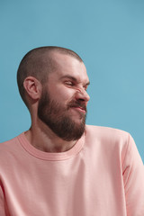 Obraz premium Young man with disgusted expression repulsing something, isolated on the blue