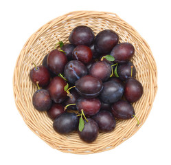 Sweet and ripe plums in basket on white