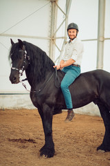 man riding brown horse on the countryside
