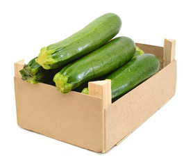 fresh zucchini's (Cucurbita pepo) in a wooden crate on a white background