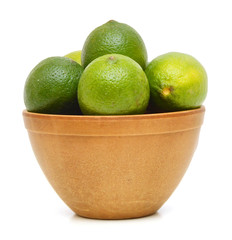 A green lemons on wooden bowl