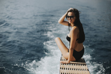 Pretty woman relaxing on the yacht on sea at sunny day