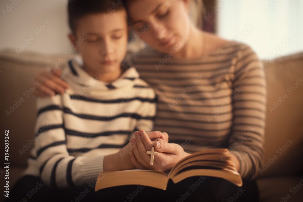 Wall mural little boy and his mother praying on sofa indoors