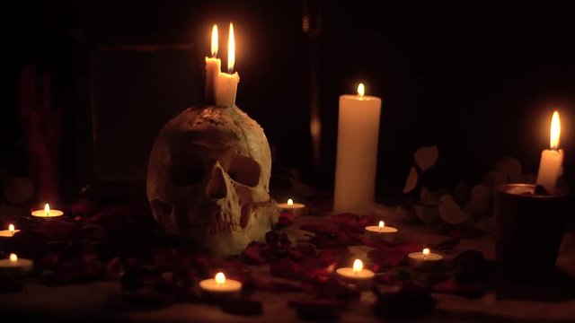 Mysterious ritual skull with candles and a flying knife