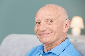 Senior man with hearing aid indoors