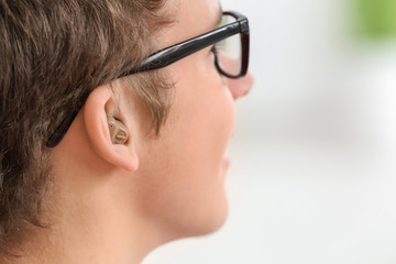 Teenage boy with hearing aid indoors