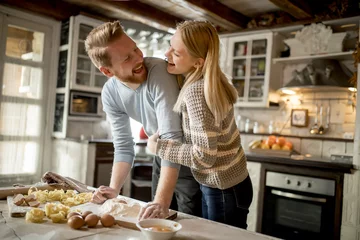 Crédence de cuisine en verre imprimé Cuisinier Loving couple preparing pasta in the kitchen