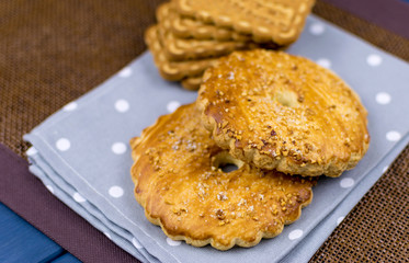 Different cookies lying on the tablecloth.