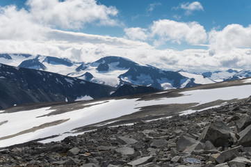 Rocky slope against the background of snow-capped mountains, Norway