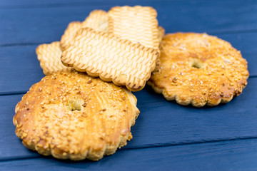 A set of cookies on a blue wooden background. Round biscuits sprinkled with nuts.